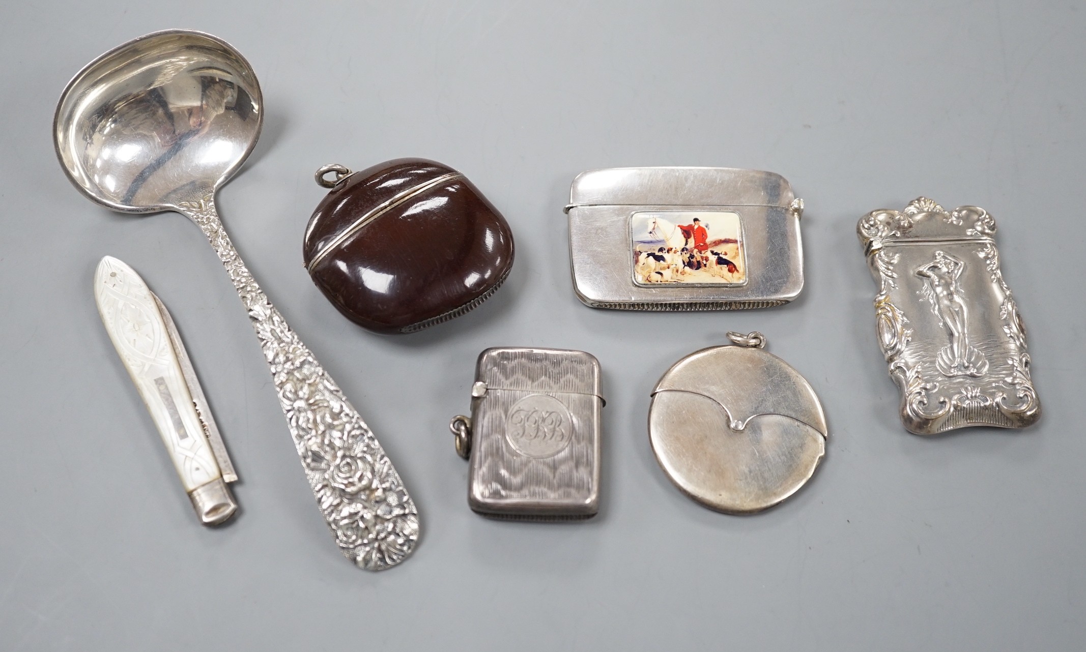 Four assorted early 20th century silver vesta cases, including a silver gilt mounted nut, and patent action circular, together with a sterling vesta case and ornate handled sauce ladle and a mother of pearl handed silver